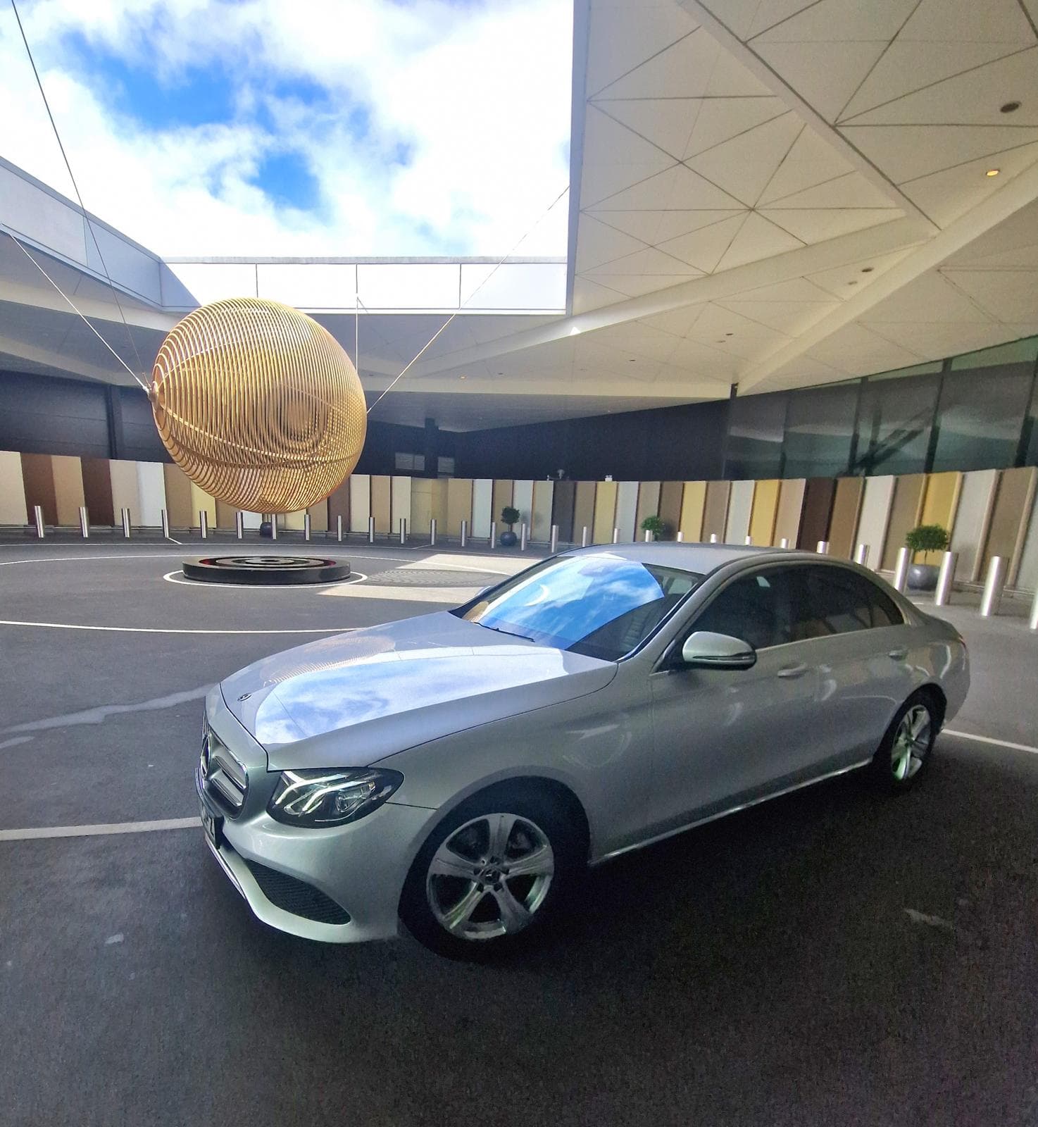 Silver executive saloon outside a covered entrance